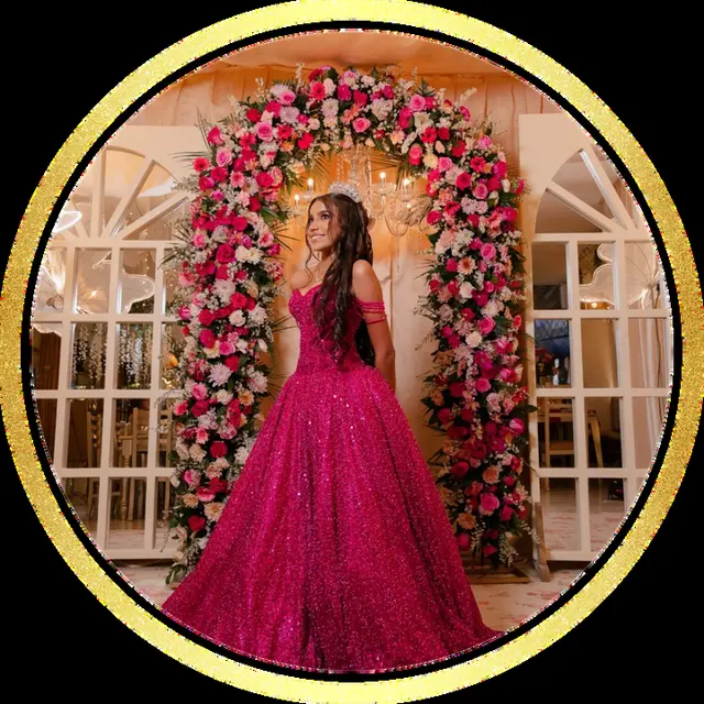 Quinceañera con vestido fucsia frente a un arco de flores